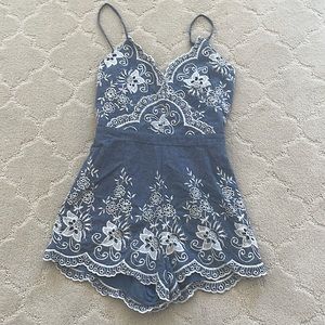 Gorgeous denim romper with white embroidery.